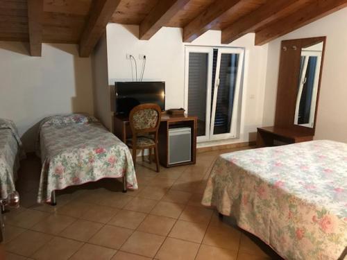 LuniにあるAlbergo Antica Luniのベッドルーム1室(ベッド2台、デスク、椅子付)