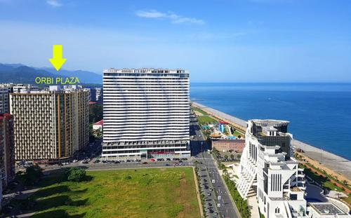 an aerial view of a tall building next to the ocean at Orbi Plaza Black Sea in Batumi