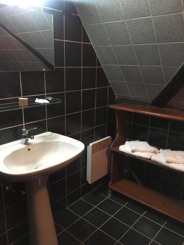 baño con lavabo y estante con toallas en Auberge du Tisserand en Gommersdorf
