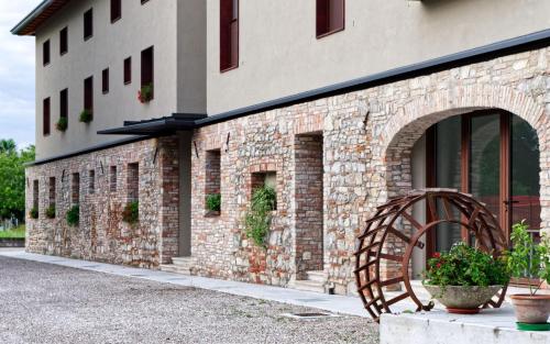 a brick building with a wheel in front of it at La Selce Farmhouse in Bagnaria Arsa