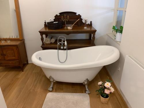 a white bath tub in a bathroom with a sink at Lucerna - dům s duší Příbor in Příbor