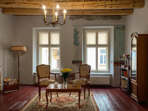 a living room with a table and chairs and windows at Lucerna - dům s duší Příbor in Příbor