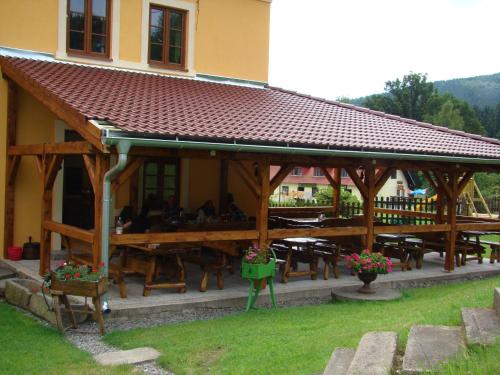a pavilion with tables and benches in front of a building at Pension Pod Lipou in Loučovice