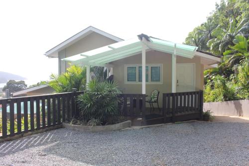 a small house with a porch with a fence at Stephna Residence in Anse Boileau