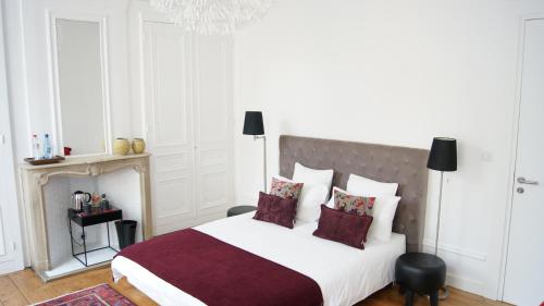 a bedroom with a large white bed and a chandelier at Au Cœur De Lille in Lille