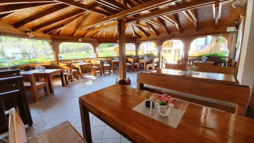 a restaurant with wooden tables and chairs and tables at Villa Knezevic in Plitvička Jezera