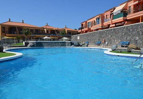 a large pool of blue water in front of buildings at Sea Mountain in Atlántico in Costa Del Silencio
