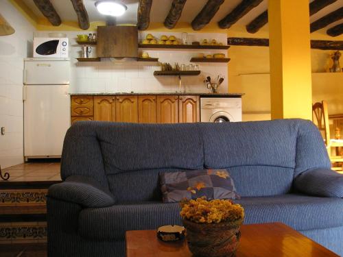 a living room with a blue couch and a table at Casa La Mestra in Herbeset