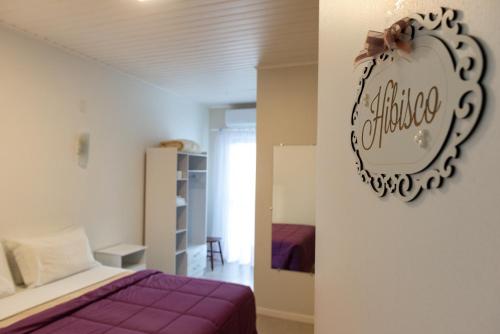 um quarto com uma cama e uma placa na parede em Pousada das Flores UpSerra em Urubici