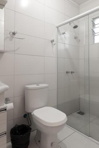 a bathroom with a toilet and a glass shower at Pousada UpSerra in Urubici