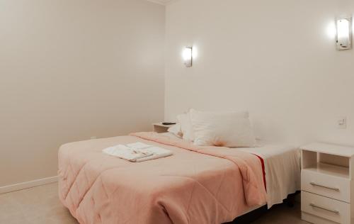 a bedroom with a bed with a pink blanket at Pousada UpSerra in Urubici