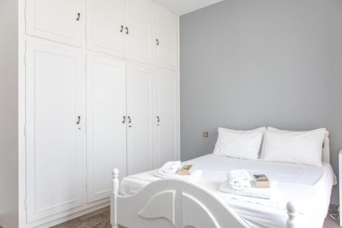 a white bedroom with a white bed with white cabinets at gatis house in Naxos Chora