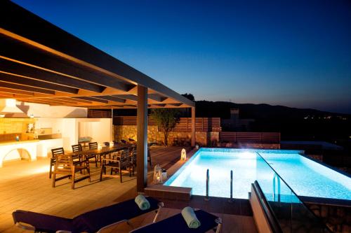 a swimming pool with chairs and a table on a patio at Luxury Villa Panorama in vlicha