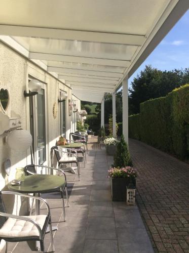 a row of tables and chairs on a patio at Hotel Pension Oranje in Valkenburg