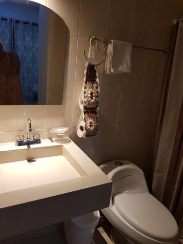 y baño con aseo y lavamanos. en Villas del Carmen Holbox en Holbox Island
