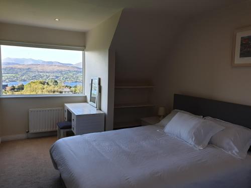 a bedroom with a bed and a large window at Misty Bay - Kenmare in Kenmare