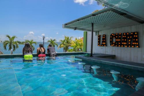 a group of people sitting around a swimming pool at Hotel Petén Express in Flores