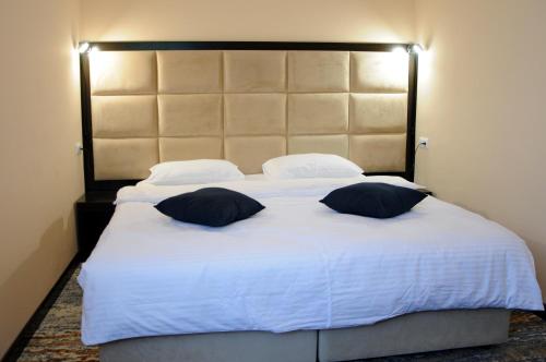 a bedroom with a large white bed with two pillows at Vanadzor Armenia Hotel in Vanadzor