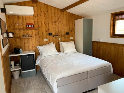 1 dormitorio con 1 cama grande y TV en B&B Diemerplein, en Ámsterdam