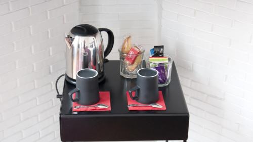 a black table with two cups and a tea kettle at Au Cœur De Lille in Lille