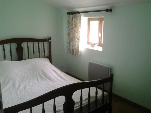 um pequeno quarto com uma cama e uma janela em Maison de village em Moltifao