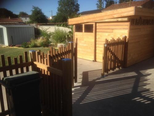 una valla de madera frente a un cobertizo de madera en Le puit du lavoir en Thiré