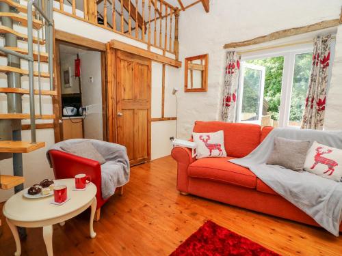 sala de estar con sofá rojo y mesa en The Mill, en Llandysul