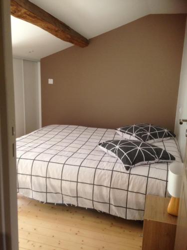 une chambre avec un lit avec une couette noire et blanche dans l'établissement Le puit du lavoir, à Thiré