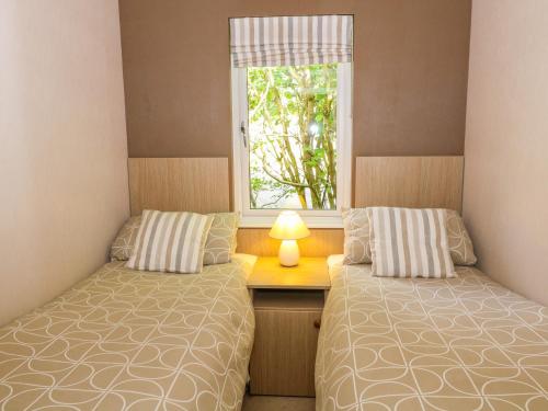 two beds in a room with a window at Willow Lodge in Windermere