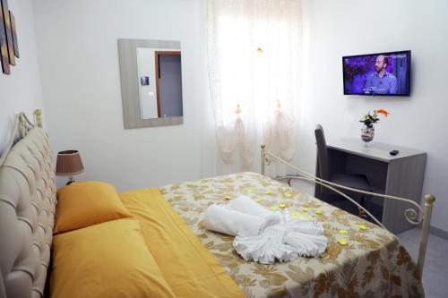 a bedroom with a bed and a tv on a wall at Affitta Camere Romy in Tropea