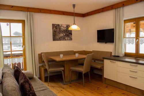 a living room with a table and a couch at Zauscherhof in Wildermieming
