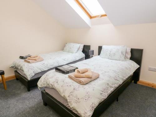 two beds with towels on them in a room at Croft Cottage in Lancaster