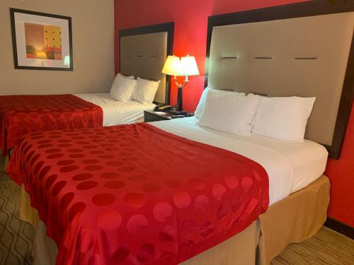 a hotel room with two beds with red walls at Ramada by Wyndham Gainesville in Gainesville