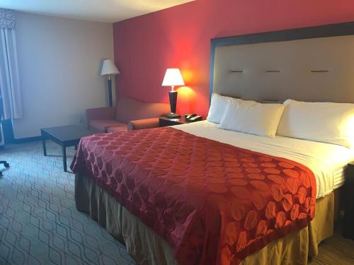 a hotel room with a large bed and a couch at Ramada by Wyndham Gainesville in Gainesville