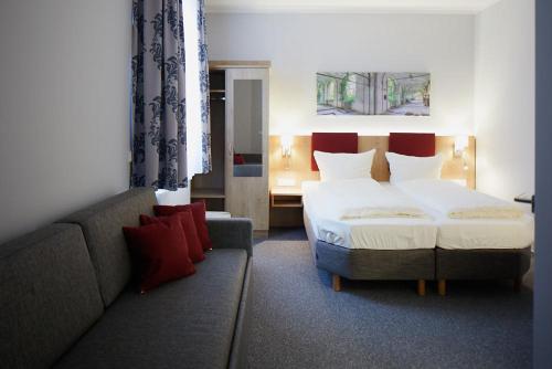 une chambre d'hôtel avec un lit et un canapé dans l'établissement Gasthof Pension Kettler, à Oberasbach
