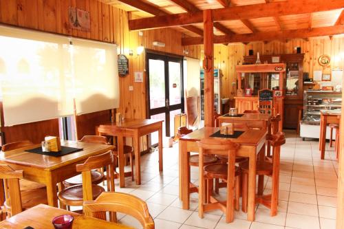 a restaurant with wooden tables and chairs and a screen at Cabanas L'ESCALE in Coñaripe