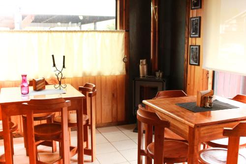 a dining room with a wooden table and chairs at Cabanas L'ESCALE in Coñaripe