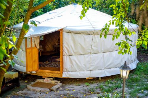 a yurt with a wooden door in a yard at Alföldi Jurta Ruzsa in Ruzsa