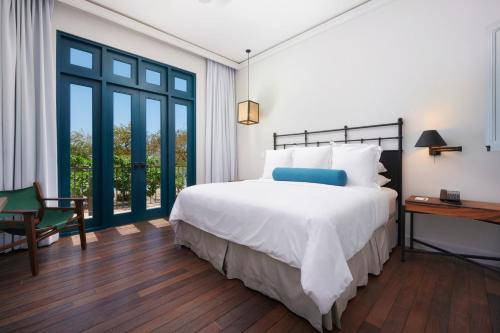 Santarena Hotel at Las Catalinas في بلايا فلامنغو: غرفة نوم بسرير ابيض كبير ونافذة