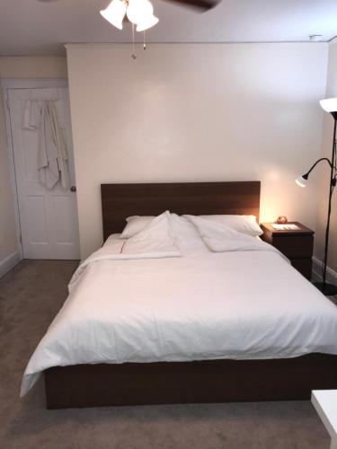 una camera da letto con un grande letto bianco e una lampada di 纽约ZUHUA长岛(Hofstra University) （霍夫斯特拉大学）民宿！ a Hempstead