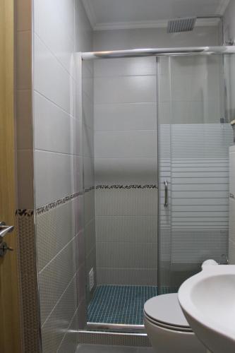 a bathroom with a shower with a toilet and a sink at Apart Baía do Sado I in Setúbal