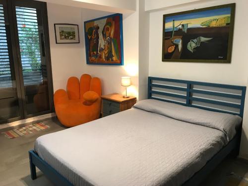 1 dormitorio con 1 cama y 1 silla naranja en Villa Le Lanterne Pool & Relax, en Mondello