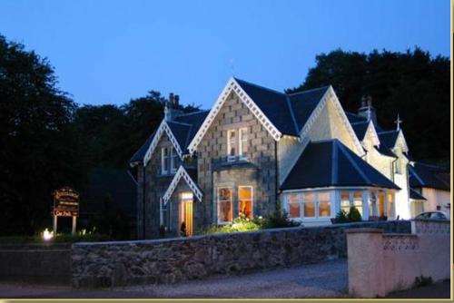 a large house with a stone wall at Buccleuch Guest House in Fort William