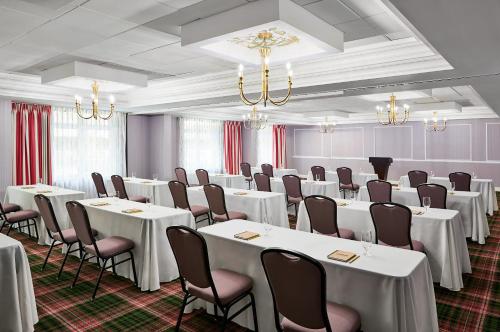 a conference room with white tables and chairs and chandeliers at Graduate by Hilton Columbia SC in Columbia