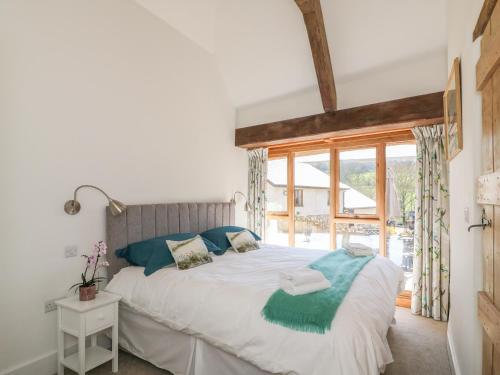 a bedroom with a large bed and a window at The Old Smithy in Honiton