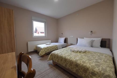 una camera d'albergo con due letti e una finestra di Olimp a Kraljevo