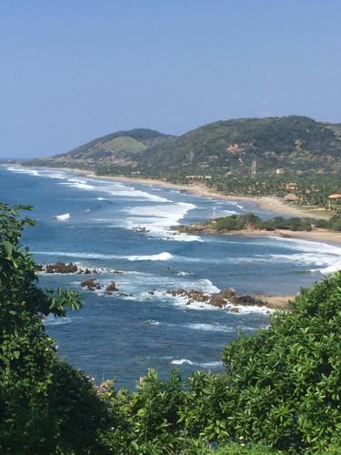 a view of a beach from a hill at Casa de la Costa in Troncones