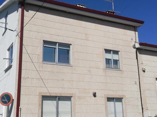 d'un bâtiment avec quatre fenêtres sur son côté dans l'établissement Apartamento Calzada II, à Saint-Jacques-de-Compostelle