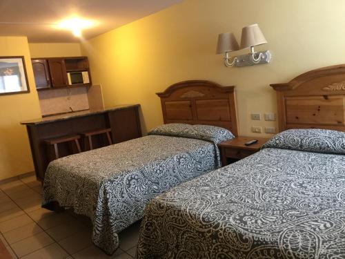 a hotel room with two beds and a kitchen at El Ejecutivo Aparthotel in Ciudad Obregón