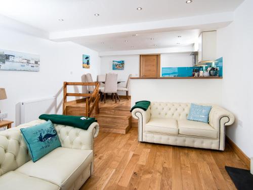 ein Wohnzimmer mit zwei weißen Sofas und einem Tisch in der Unterkunft The Captain's Bank in Porthmadog
